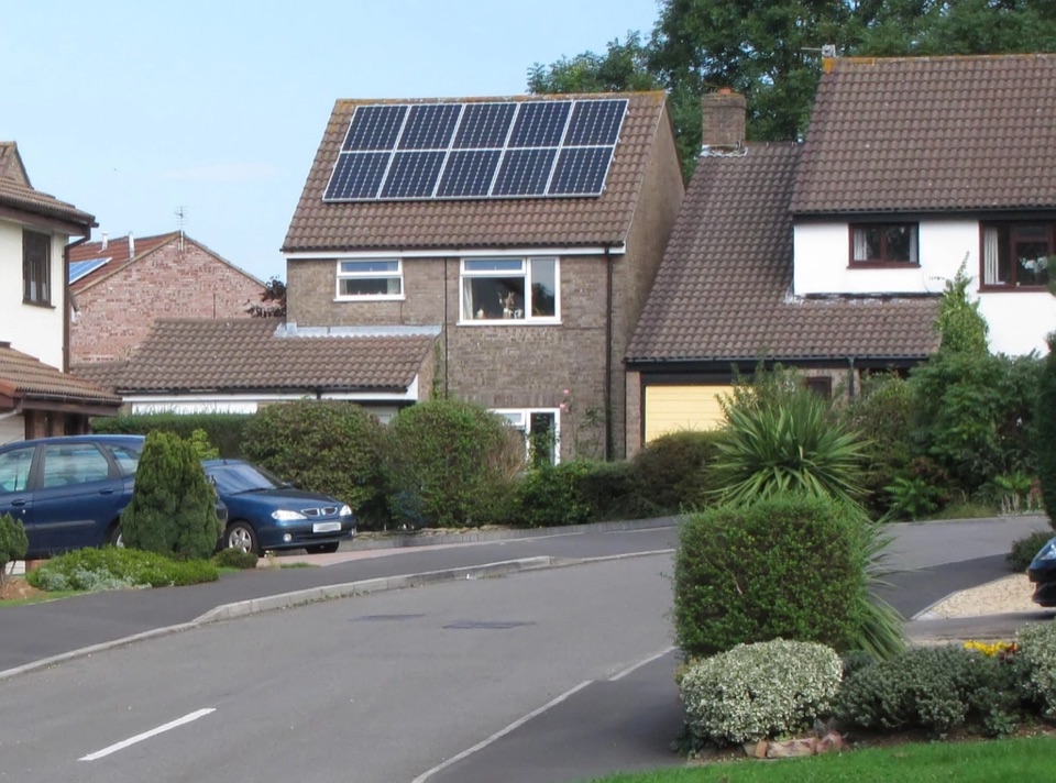 Solar panels on the pitched roof of a house on a suburban street in England