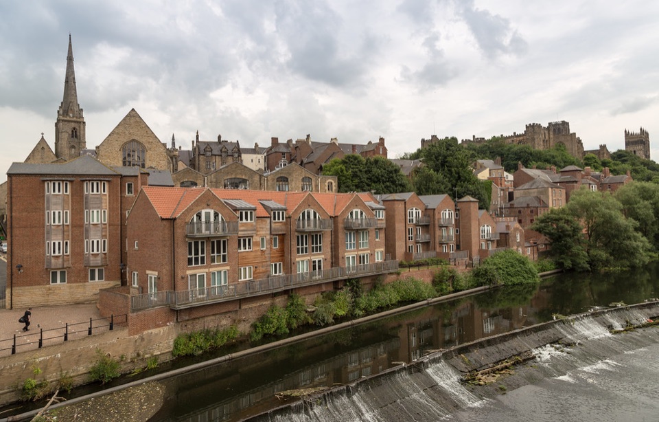 Brick houses with balconies standing above the River Wear at Durham